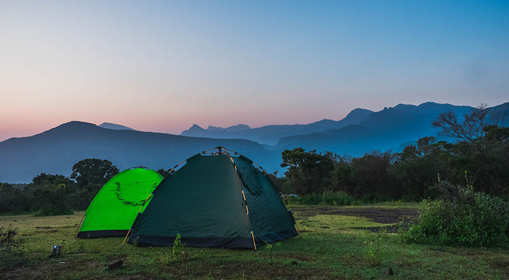 Zelte auf Wiese vor Berglandschaft